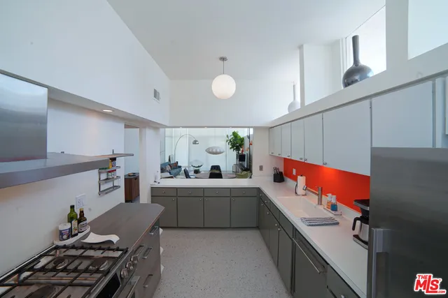 a kitchen with stainless steel appliances hardwood floor sink stove and wooden cabinets