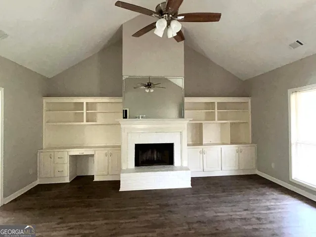 a living room with a fireplace and wooden floor