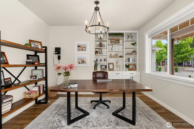 a view of a workspace with furniture and a window