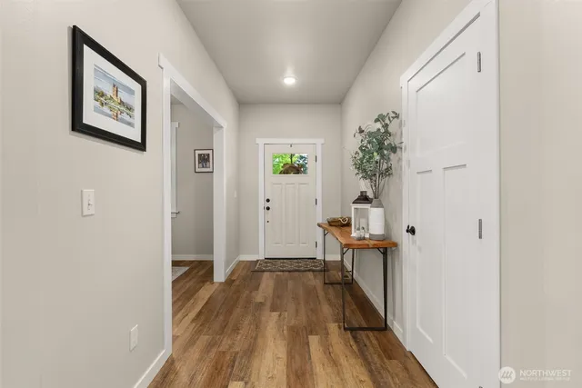 a view of a hallway with wooden floor and a living room