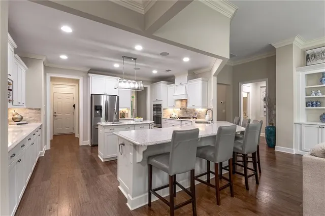 a bathroom with a granite countertop toilet a sink and a large mirror