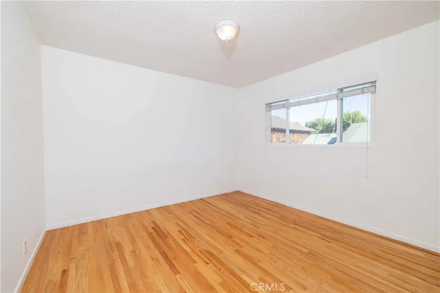 a view of a room with wooden floor and a window