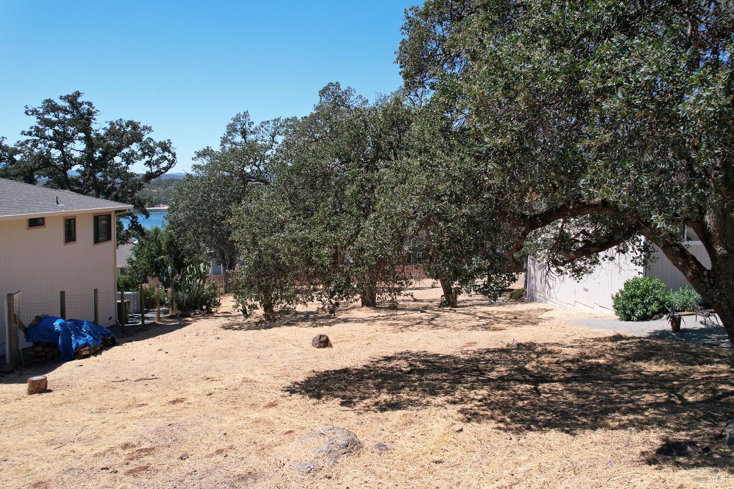18903 Deer Hill Road Hidden Valley Lake, CA 95467 - Photo 13 of 32 Lake views from the vacant lot for sale. The current owners live right next door and have a lot of similar size and topography. Buy this lot and create the yard of your dreams on this blank slate studded with beautiful Oak trees.