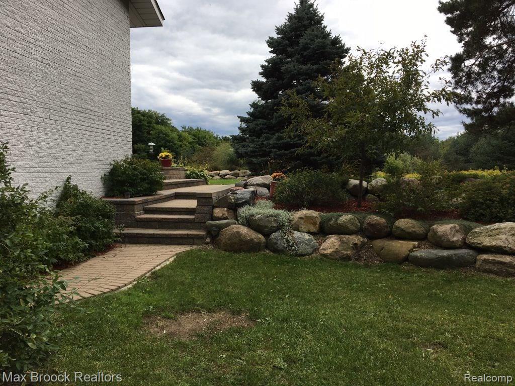 9895 Rattalee Lake Road Clarkston, MI 48348 - Photo 26 of 34 The paver walkway and steps lead to the back acreage for outdoor fun!