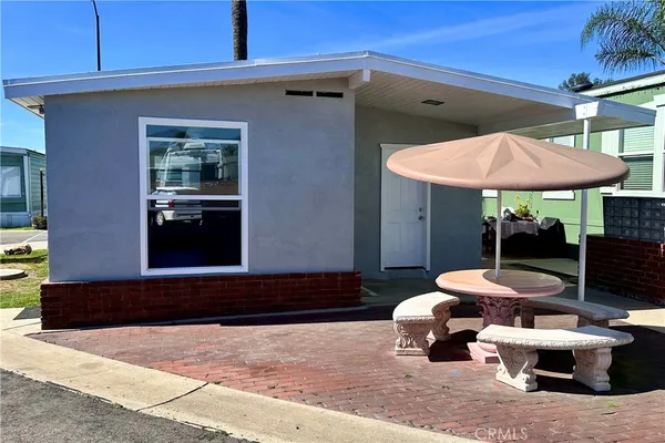 a patio with a table and chairs under an umbrella