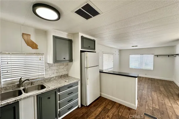 a kitchen with stainless steel appliances granite countertop a sink and a refrigerator