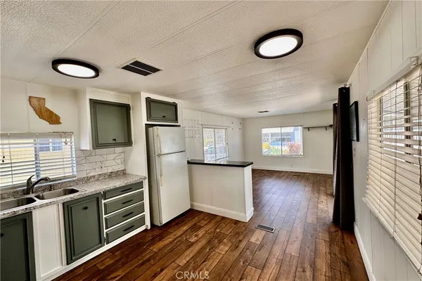 a kitchen with granite countertop a stove cabinets and wooden floor