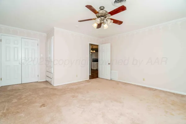 an empty room with closet and a chandelier fan