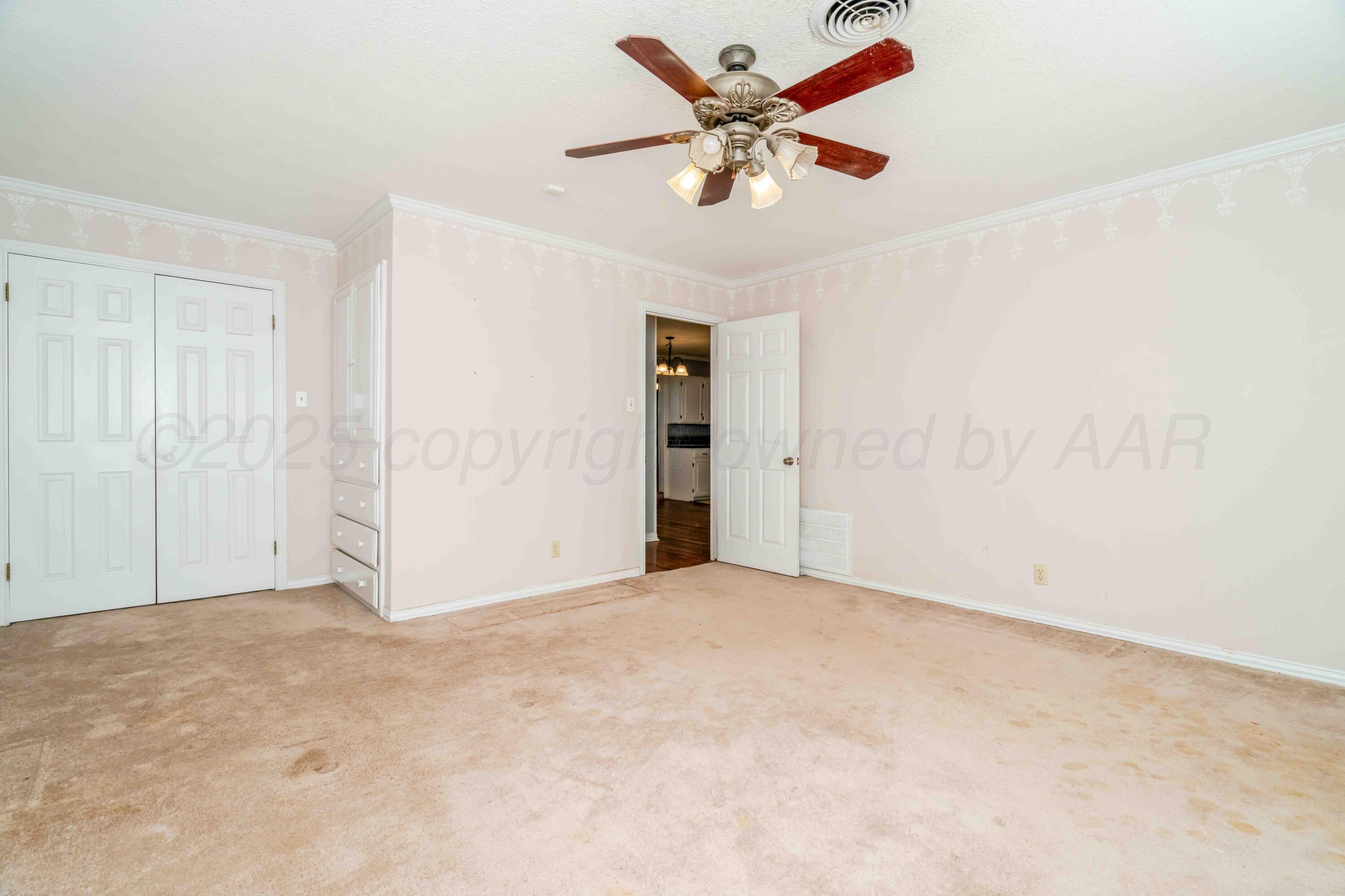 39 Crockett Drive Tulia, TX 79088 - Photo 17 of 29 an empty room with closet and a chandelier fan