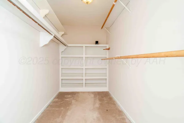 a view of walk in closet with empty racks