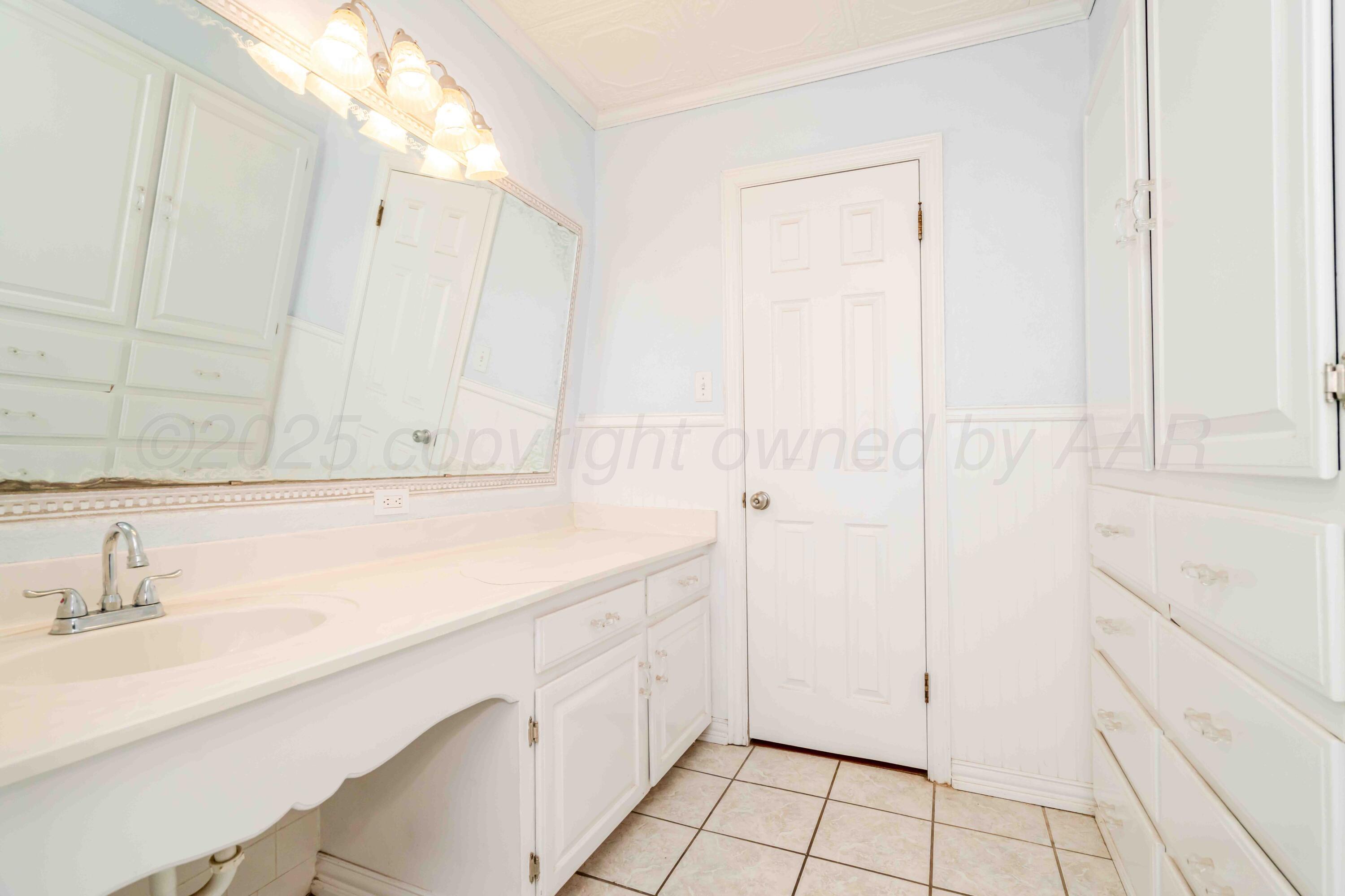 39 Crockett Drive Tulia, TX 79088 - Photo 21 of 29 a bathroom with a sink and a mirror