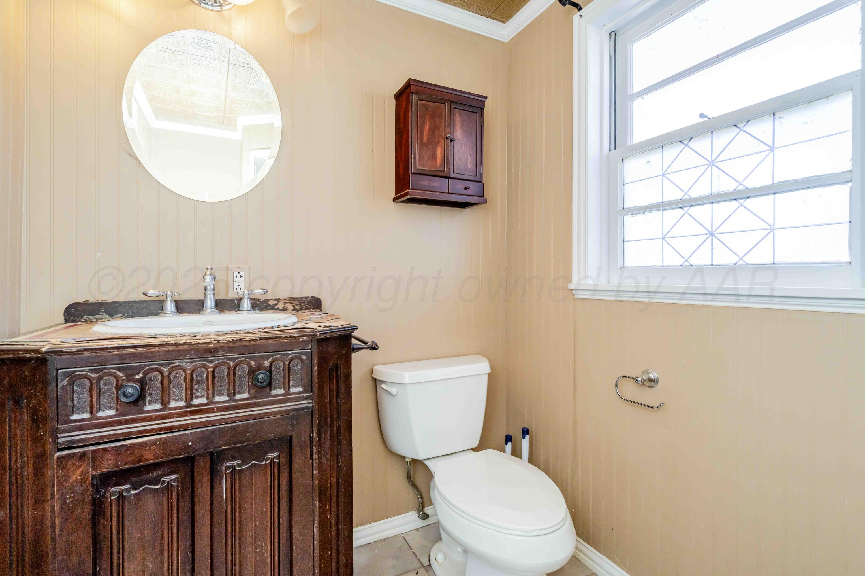 39 Crockett Drive Tulia, TX 79088 - Photo 24 of 29 a bathroom with a toilet a sink and a mirror