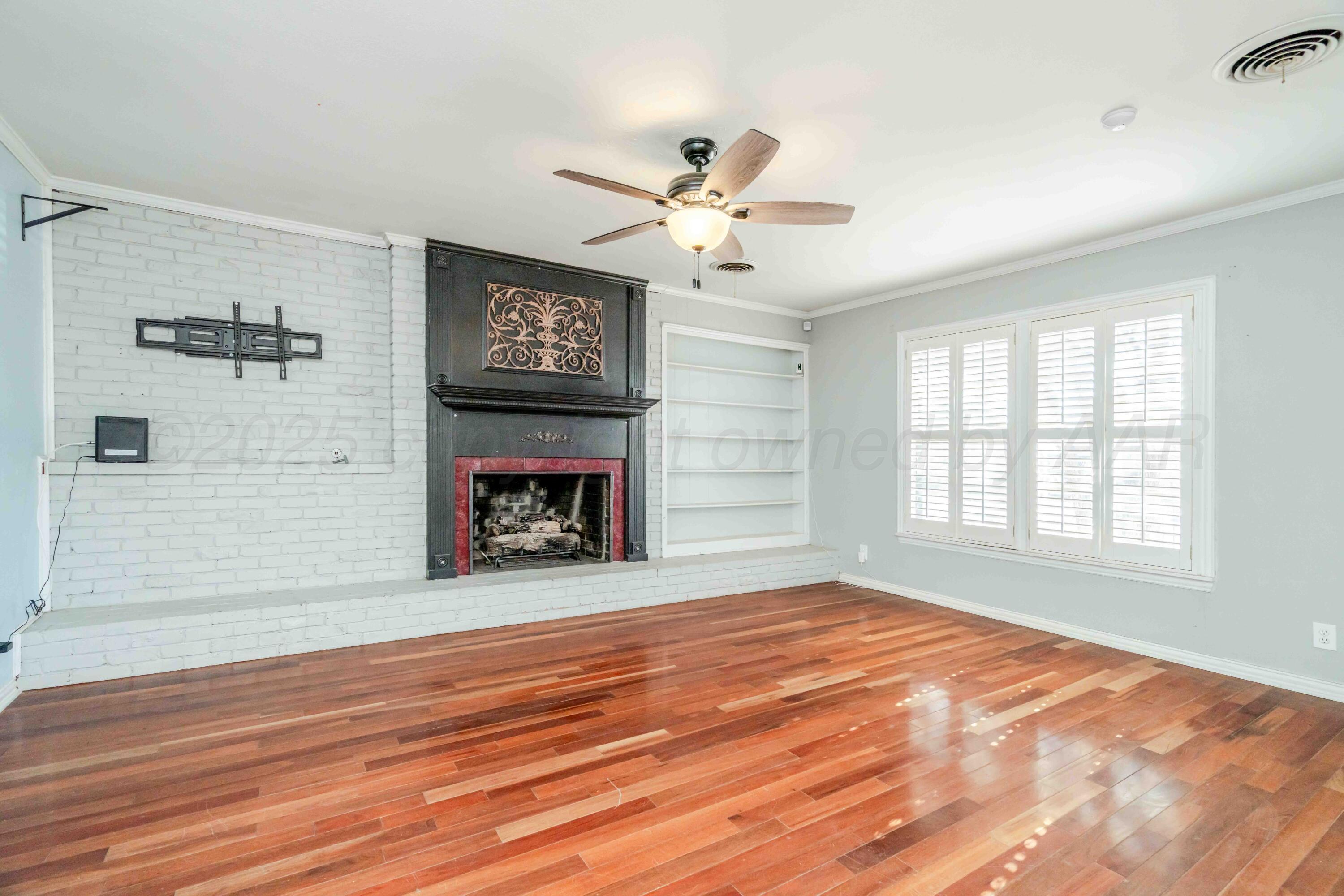 39 Crockett Drive Tulia, TX 79088 - Photo 6 of 29 a view of an empty room with a fireplace and a window