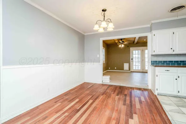 a view of a room with wooden floor and cabinets