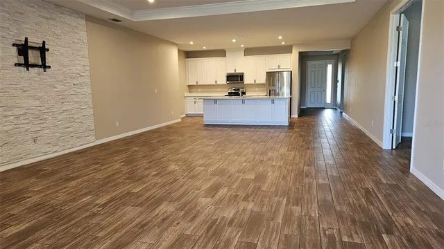 a view of a kitchen with wooden floor and a window