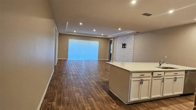 a kitchen with a sink and wooden floor