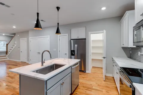 a kitchen that has a sink a stove and a refrigerator