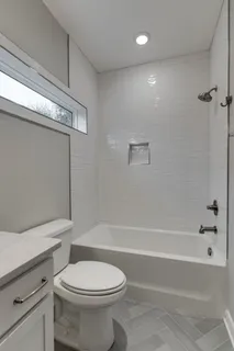 a bathroom with a toilet and a bath tub