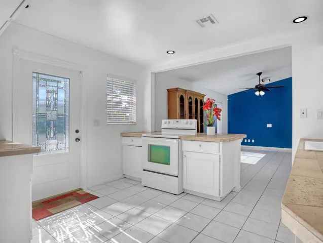 a kitchen with white cabinets and sink