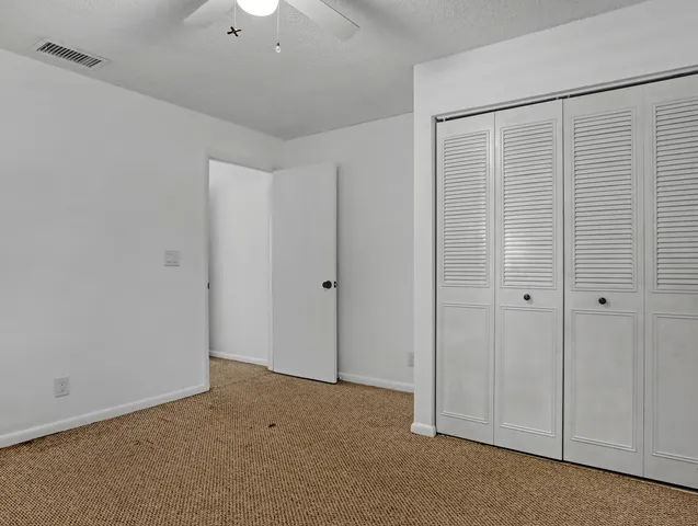 a bathroom with a granite countertop sink a toilet and mirror