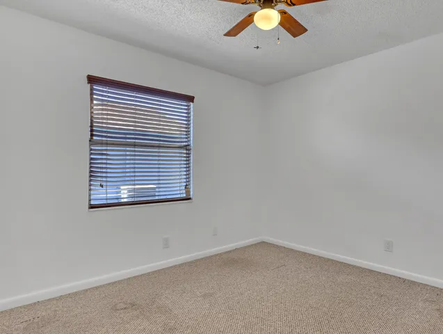 an empty room with chandelier fan