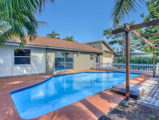 a front view of a house with a yard and potted plants