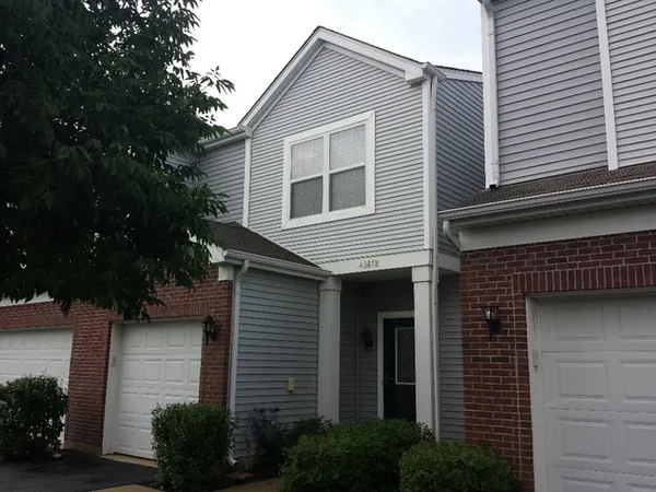 a front view of a house with plants