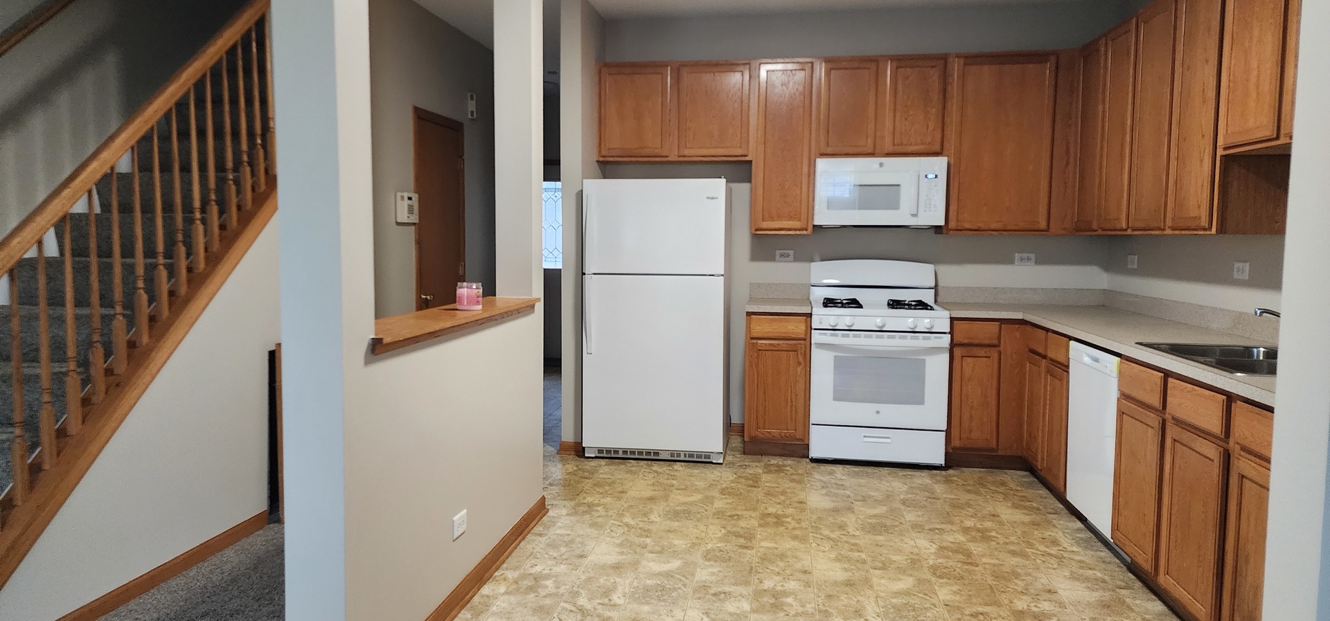 4561 Garritano Street, Unit B Yorkville, IL 60560 - Photo 3 of 11 a kitchen with white cabinets and white appliances