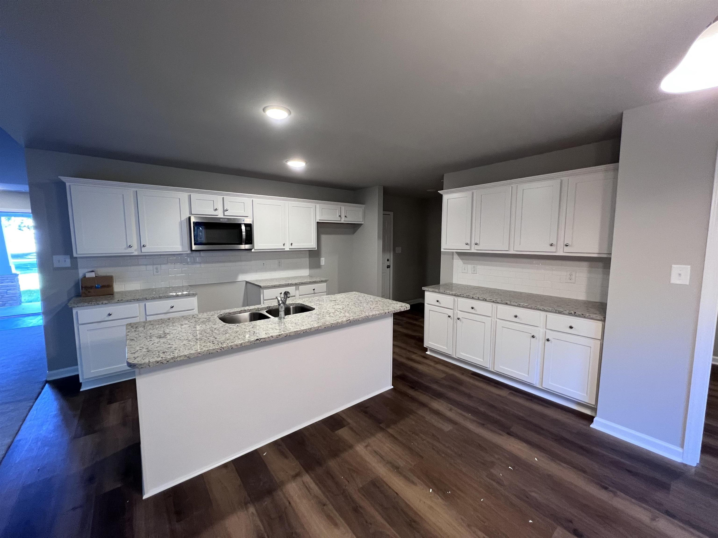 528 Roberts Road Willow Spring, NC 27592 - Photo 8 of 19 a kitchen with granite countertop white cabinets and white appliances