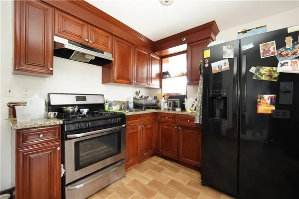 a kitchen with stainless steel appliances granite countertop a stove a refrigerator and a sink