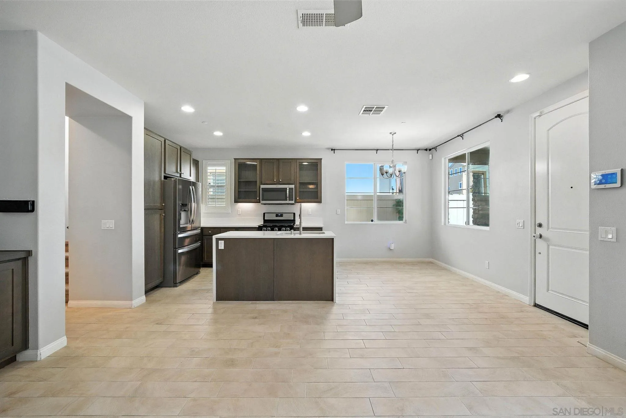 1319 Keck Road Chula Vista, CA 91913 - Photo 6 of 49 a kitchen with stainless steel appliances kitchen island granite countertop a refrigerator oven a sink with dishwasher and white cabinets