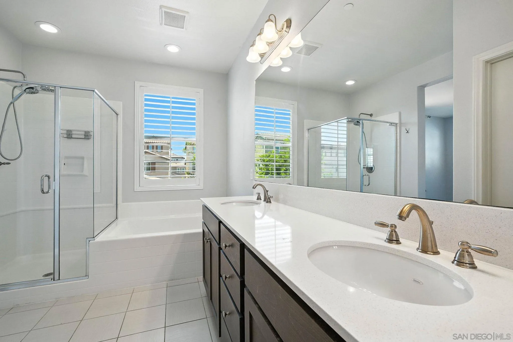 1319 Keck Road Chula Vista, CA 91913 - Photo 10 of 49 a bathroom with a granite countertop sink a large mirror and a bathtub with shower