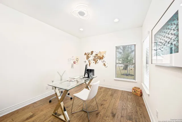 a view of a workspace with furniture and a window