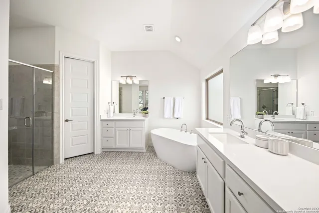 a large bathroom with a double vanity sink a mirror and a bathtub