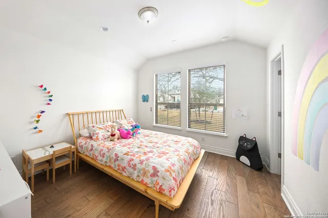 a bedroom with a bed and a wooden floor