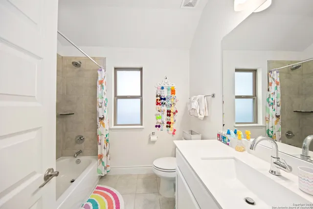 a bathroom with a sink toilet tub vanity and shower