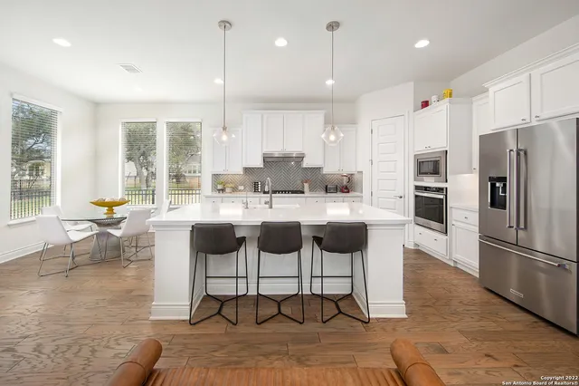 a kitchen with stainless steel appliances kitchen island granite countertop a refrigerator and a stove top oven