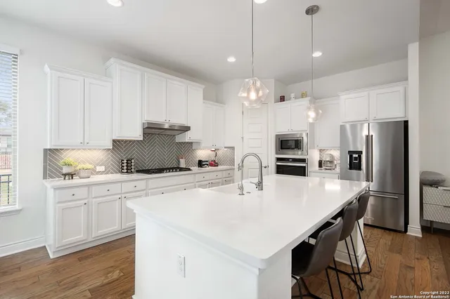 a kitchen with a center island a counter space stainless steel appliances and cabinets