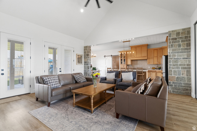2013 South 100 West Perry, UT 84302 - Photo 12 of 49 Vaulted ceilings highlight this living area featuring wood-finish flooring and multiple glass-paned doors