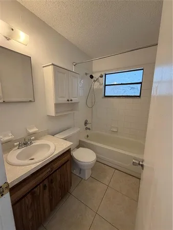 an empty room with windows and ceiling fan