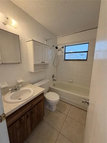 an empty room with windows and ceiling fan