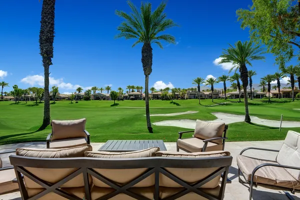 a view of a patio with a table chairs and a yard