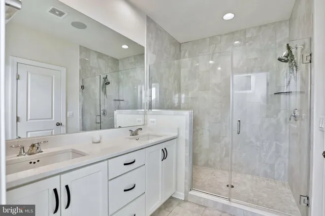 a bathroom with a shower tub double vanity sink and mirror