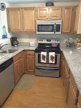161 Stone Ridge Road, Unit 161 Franklin, MA 02038 - Photo 2 of 23 a kitchen with stainless steel appliances granite countertop a stove microwave and cabinets