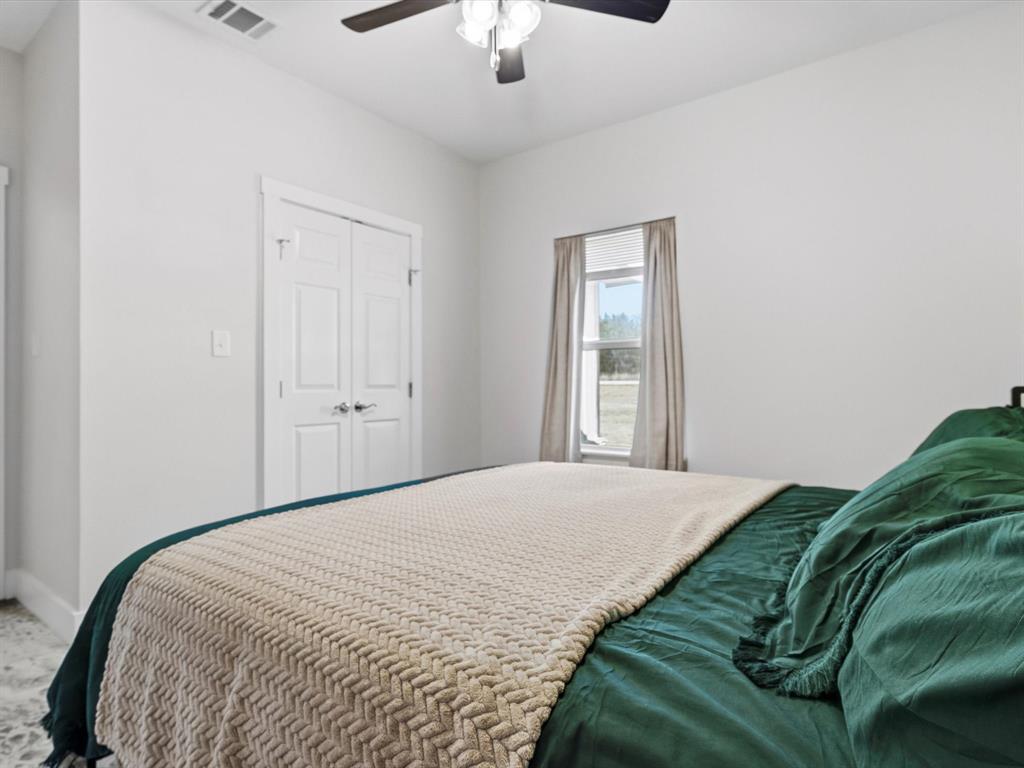 123 Kriston Lane Springtown, TX 76082 - Photo 19 of 39 a bedroom with a bed and a chandelier