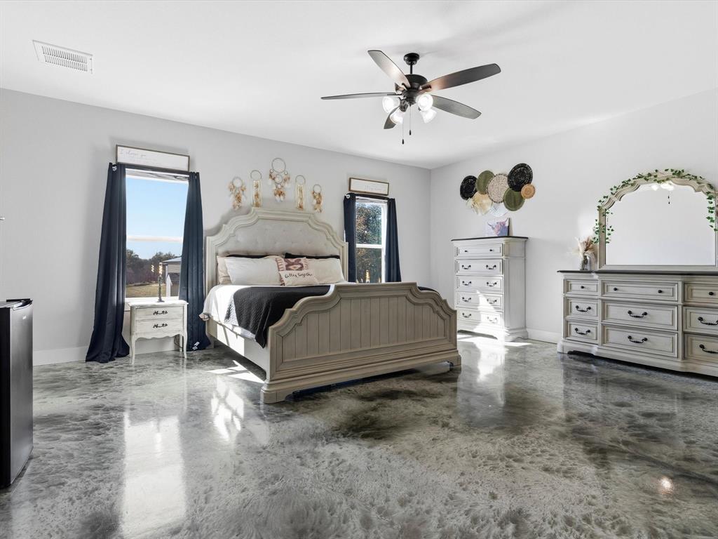 123 Kriston Lane Springtown, TX 76082 - Photo 21 of 39 a bedroom with a large bed and a chandelier