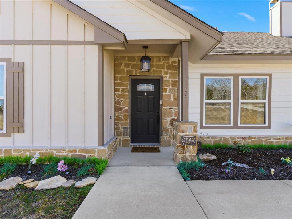 123 Kriston Lane Springtown, TX 76082 - Photo 5 of 39 a front view of a house with a garden