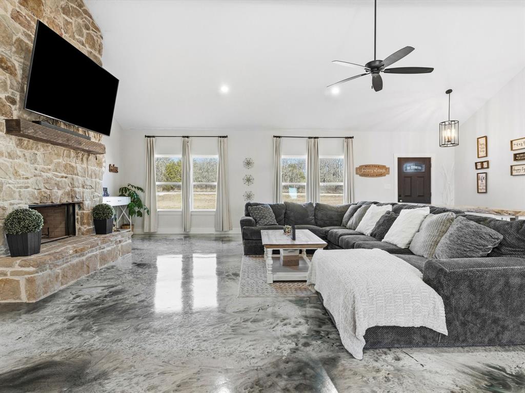 123 Kriston Lane Springtown, TX 76082 - Photo 6 of 39 a living room with furniture a fireplace and a flat screen tv