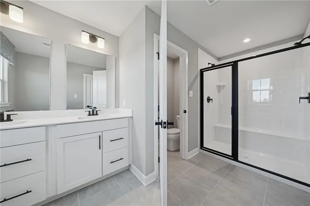 a spacious bathroom with a shower sink and a mirror