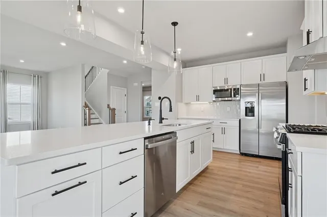 a kitchen with white cabinets stainless steel appliances and sink